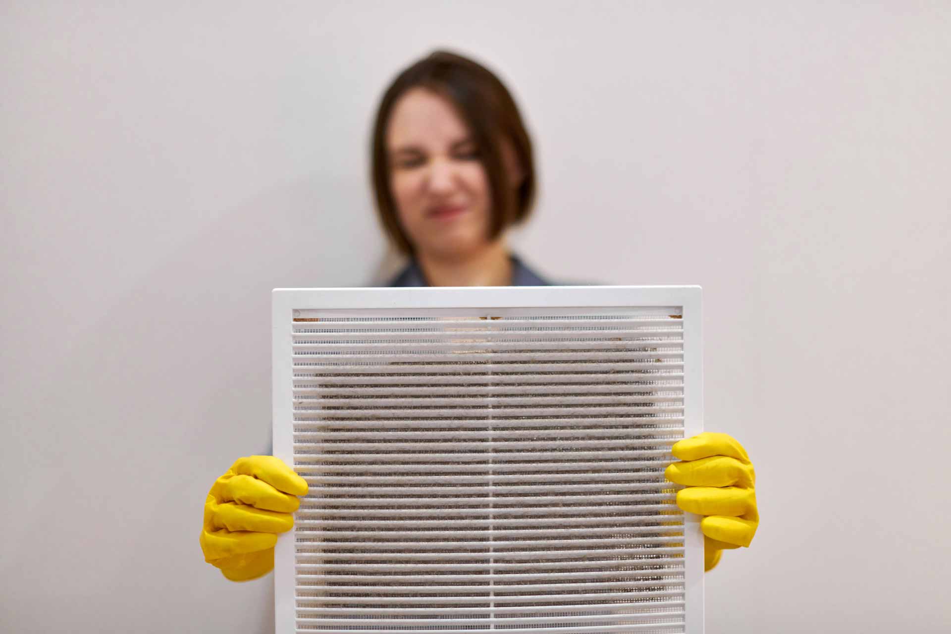 Woman holding out a dusty, dirty air vent